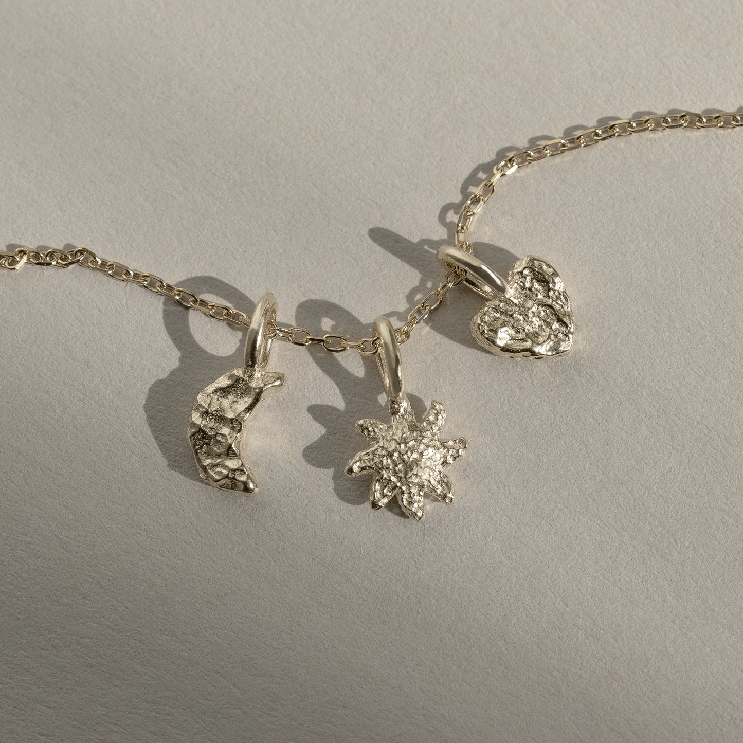 Sun + Moon + Heart charm pendant 9k 375 guld solid gold feminine feminin sol måne hjerte cute petite dainty intricate molten textured tekstur symbol classic klassisk simple simpel modern timeless elegant handcraftedcph handcrafted jewelry copenhagen handmade danish design contemporary